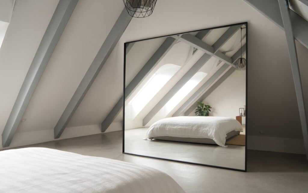 attic bedroom with mirror to make space look bigger